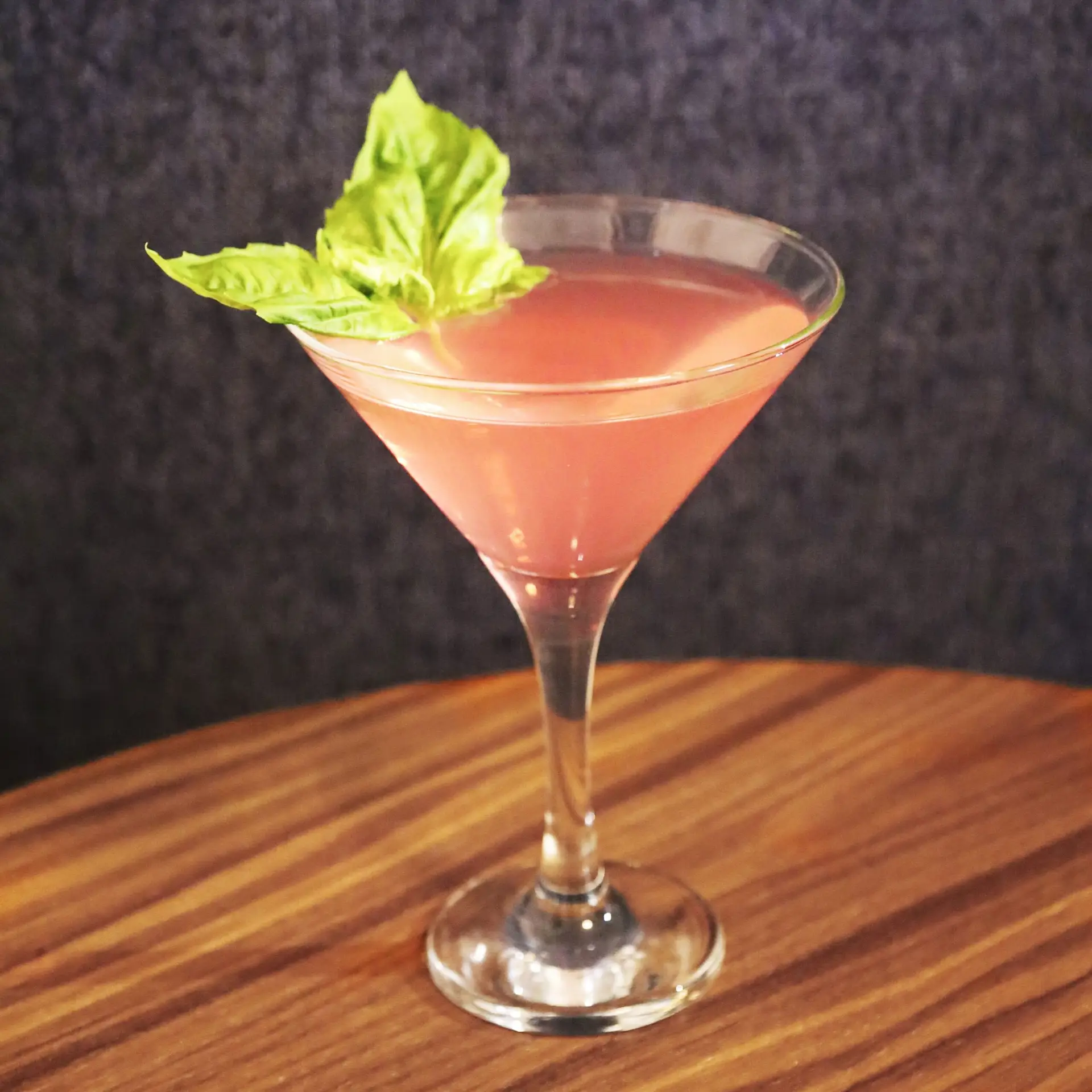 Drinks XXL Strawberry Basil Martini cocktail in a glass, garnished with fresh basil leaves.