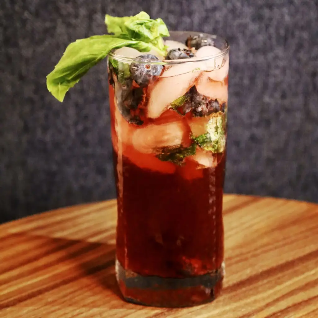 Drinks XXL blueberry moscato wine cocktail garnished with fresh blueberries and mint leaves.