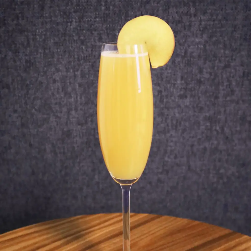 Drinks XXL Peach Bellini cocktail in a flute glass, garnished with a peach slice.