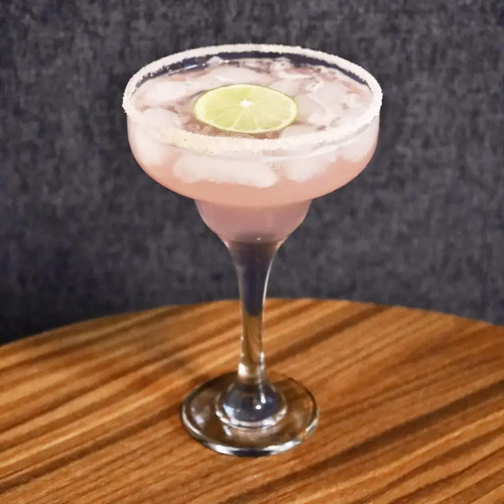 Drinks XXL Guava Margarita cocktail with a salted rim and lime slice garnish.