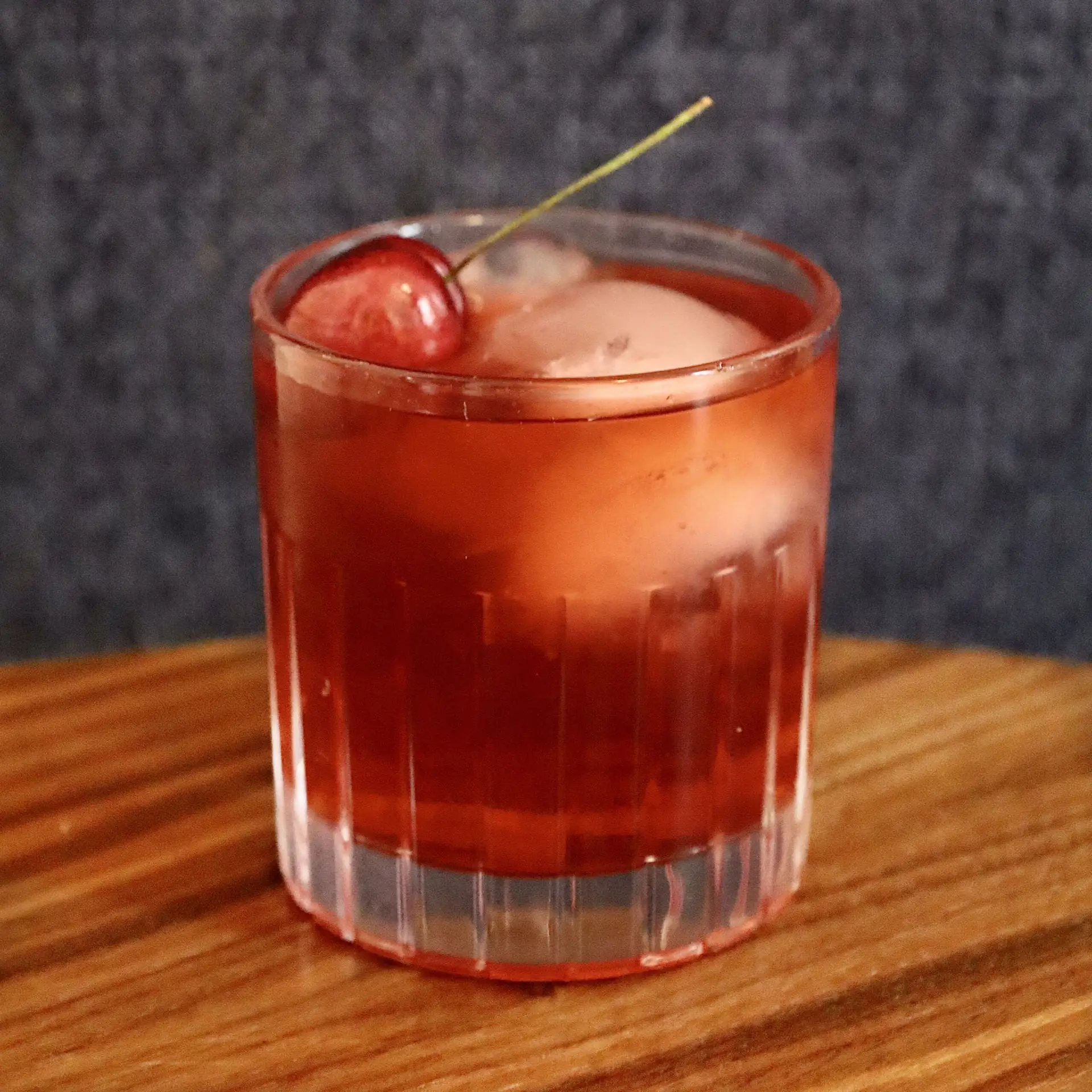 Drinks XXL Cherry Old Fashioned cocktail in a glass with ice and cherry garnish.